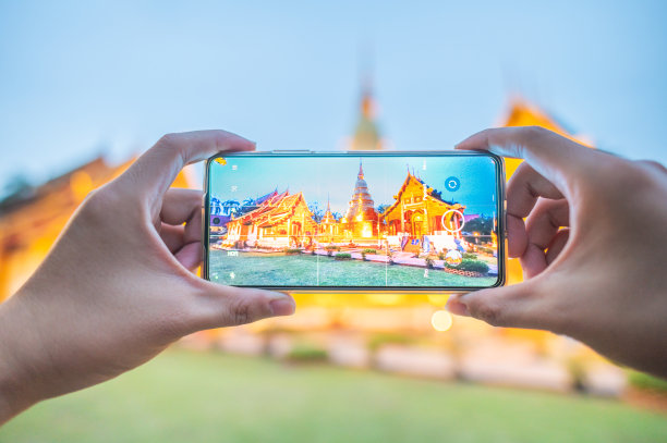 游客用手机拍摄照片，在清迈与散景背景的神奇景色Wat Phra Singh寺庙图片下载