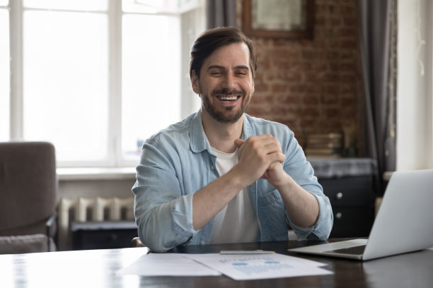 商人坐在桌前微笑看着镜头感到幸福图片下载