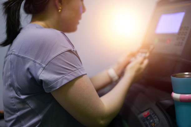 女人在跑步机上使用手机图片下载