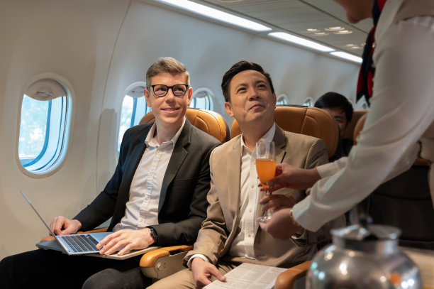 空姐在飞机上为商人提供橙汁图片下载