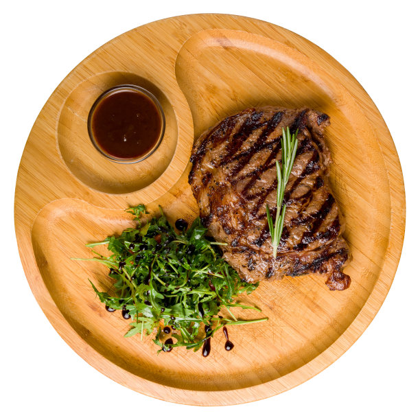 多汁的肋眼牛排放在木盘子上，有芝麻菜，西红柿和胡椒酱俯视图孤立在白色背景上图片下载