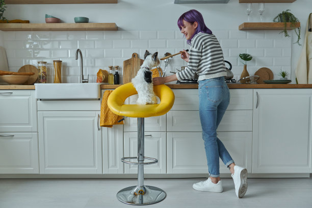 快乐女人在厨房做饭的后视图图片下载