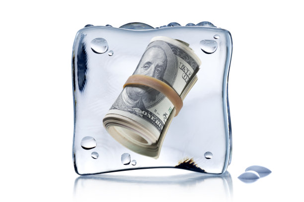 一卷一卷的美元钞票冻在冰块里图片下载