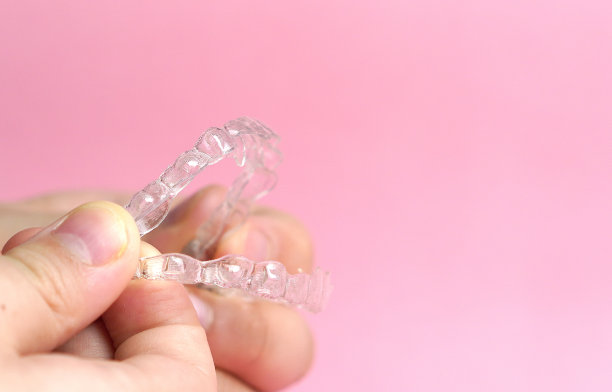 手握隐形支撑在粉红色的背景图片下载