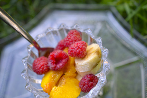 水果，香蕉，覆盆子和桃子在一个玻璃碗图片下载