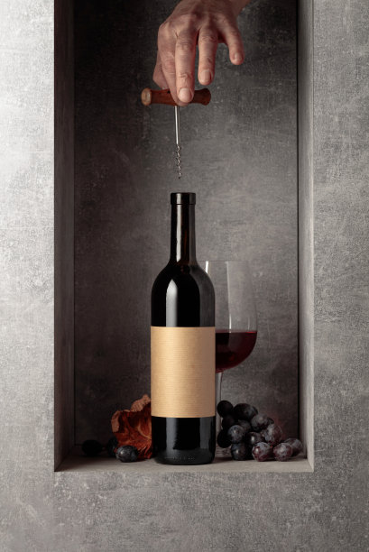 拿着开瓶器的手去拿一瓶酒。图片下载