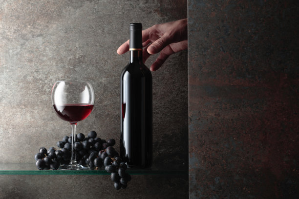 手伸向一瓶红酒。图片下载