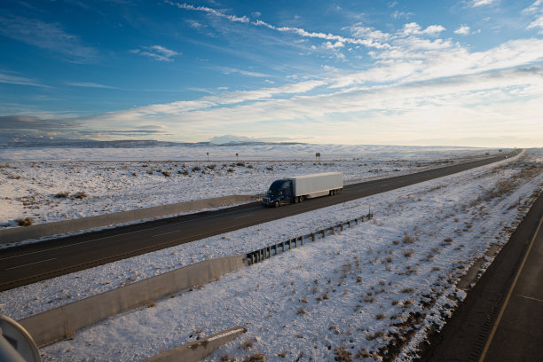 一辆半卡车在犹他州的州际公路上开着雪运送货物图片下载