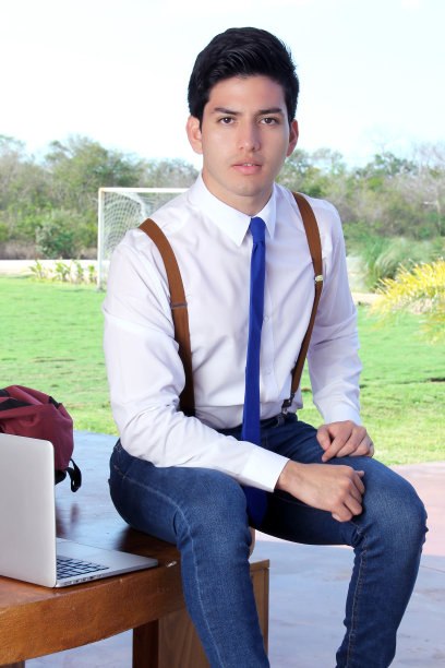 年轻学生穿着牛仔裤，白色衬衫和蓝色领带图片下载