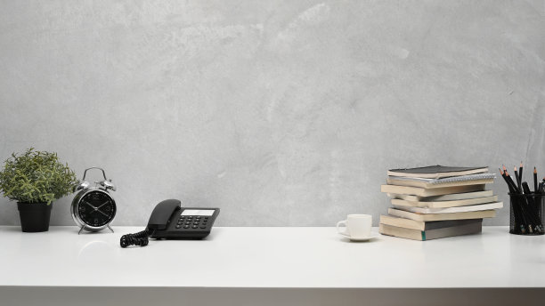 家庭办公室办公桌，盆栽植物，书籍，闹钟和铅笔盒。复制空间为您的广告文本。图片下载