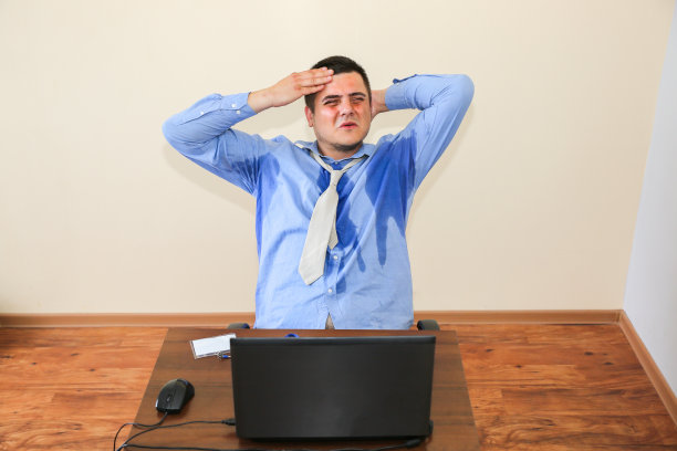 出汗上班族。湿的衬衫。糟糕的工作条件。不愉快的经理。夏天热。大楼里没有空调。图片下载