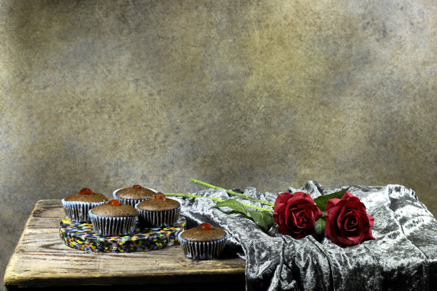 自制的巧克力坚果松饼，木桌上装饰着蜜饯樱桃，还有红玫瑰花和纺织品图片下载