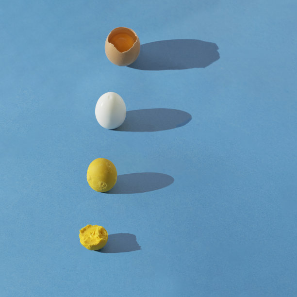 彩色图案由生裂蛋、煮蛋白和蛋黄组成，蓝色背景，长阴影。正方形合成与复制空间。图片下载