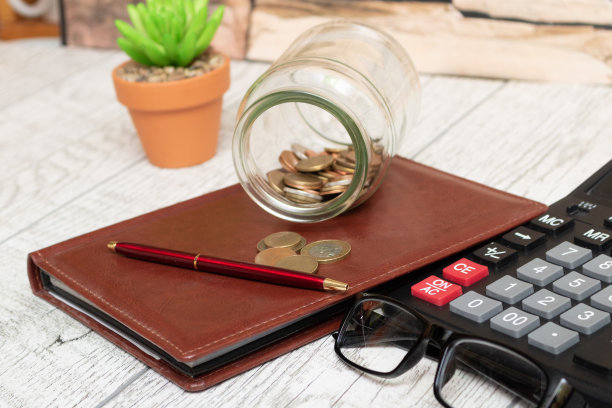 钱、硬币、计算器和一些文具放在木桌上，俯视图和复印的地方。金融背景的概念图片下载