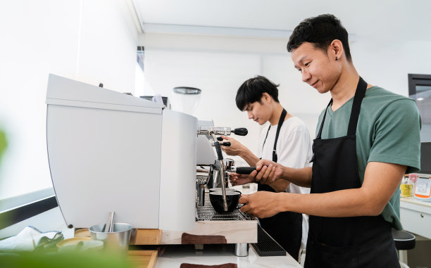 创业成功的小企业主中小企业的男人，英俊的亚洲男孩使用咖啡机在咖啡店餐厅。亚洲男子肖像咖啡师咖啡馆老板。中小企业创业商概念图片下载