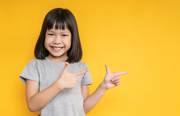 年轻有趣的聪明快乐的小可爱亚洲女孩的肖像孤立的黄色背景与拷贝空间工作室拍摄。教育为小学幼儿园、小女孩点回学校的理念图片下载
