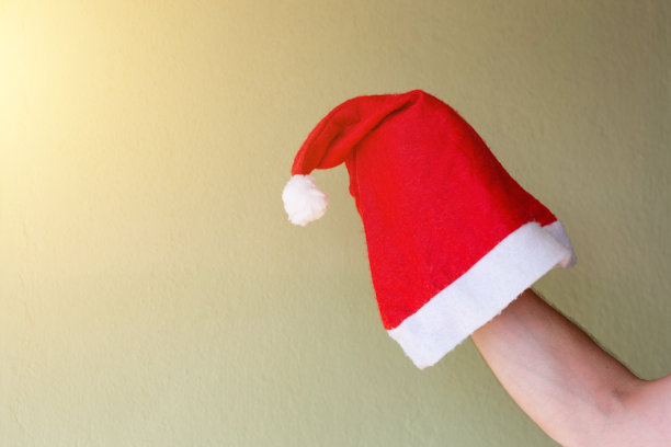 圣诞老人的帽子在手里。图片下载
