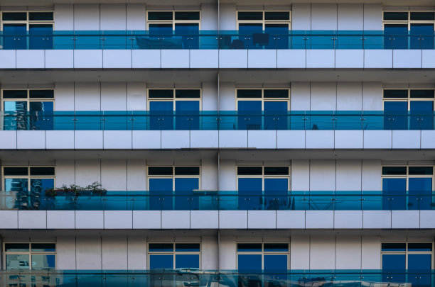 迪拜现代建筑上蓝色玻璃阳台特写，建筑背景图片下载