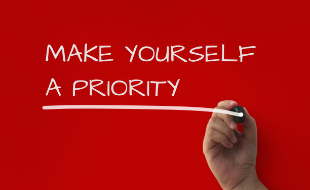 红色封面背景上的励志名言——让自己优先考虑。图片下载