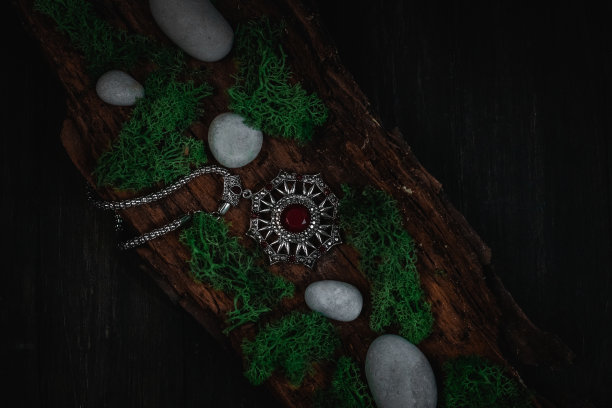 仪式护身符，黑色背景下树皮上的青苔和石头。图片下载