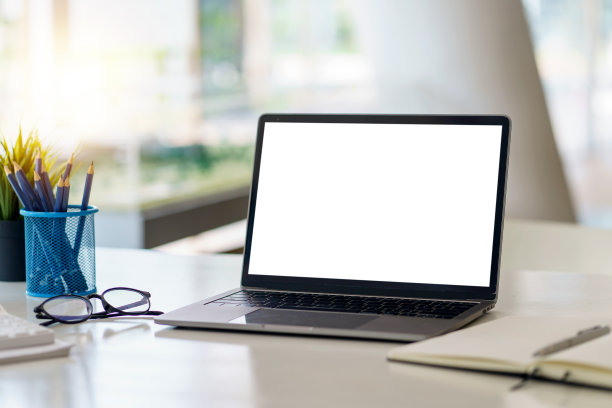 在办公室的桌子上有一台黑白屏幕的笔记本电脑。模拟。图片下载