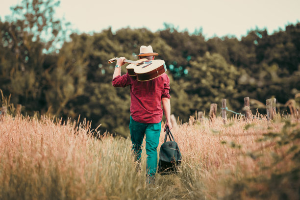 流浪的人在大自然中行走，背着原声吉他图片下载
