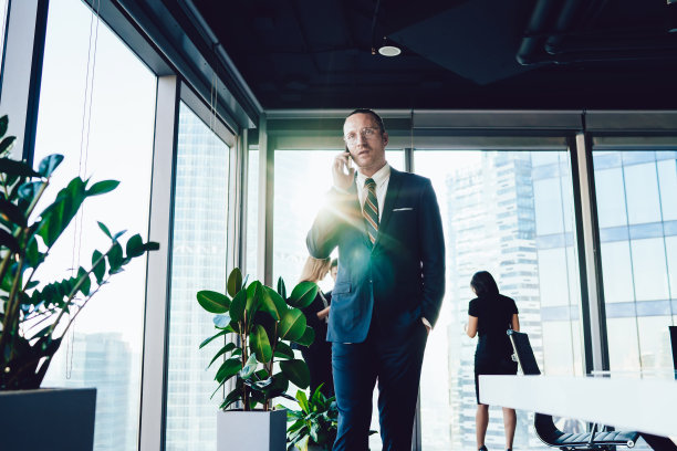 自信的男人穿着正式的西装打电话给商业伙伴讨论投资的细节，为公司连接4g无线手机，智能的男性老板通过手机应用程序打电话图片下载