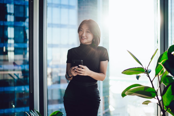 很高兴亚洲女性行政经理在办公室使用智能手机图片下载