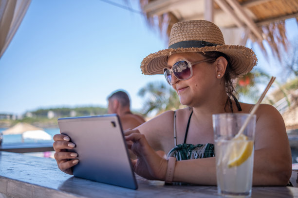 一个年轻的女孩在海滩酒吧边工作边休息图片下载