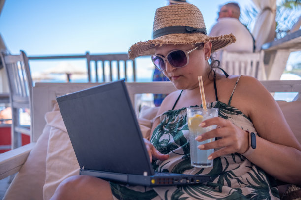 一个年轻的女孩在海滩酒吧边工作边休息图片下载