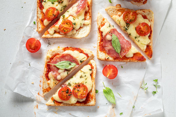 美味的热烤面包配上意大利腊肠，奶酪和罗勒。图片下载