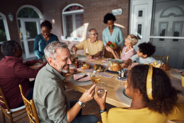 幸福的多种族父亲和女儿在院子里的家庭聚餐中举杯。图片下载
