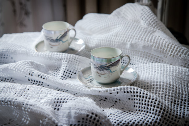早餐或咖啡休息在一个乡村，亲密和舒适的设置。咖啡提供和准备喝的杯子在钩针编织的毛巾。图片下载