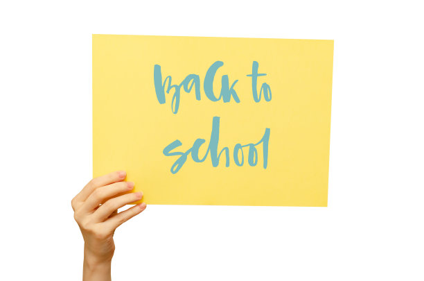 女孩手里拿着一张彩色海报。手写铭文回到学校。孤立在白色图片下载