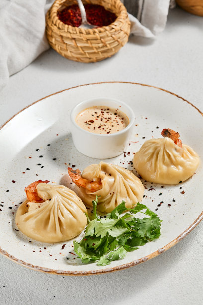 白色混凝土背景的亚洲风味蒸饺虾。陶瓷盘酱虾仁点心。虾馄饨，极简风格。亚洲海鲜饺子。图片下载