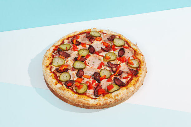 意大利披萨，配以香肠、墨西哥胡椒、火腿和红辣椒。辛辣的披萨配上蓝色和橙色的墨西哥胡椒。美式披萨外卖概念，配以彩色背景。图片下载