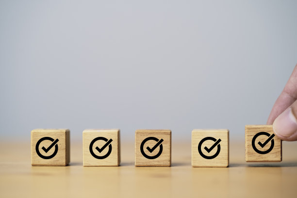 木制立方体上的打印屏幕，用于审批文件和项目概念的手放和阵列正确的标志。图片下载