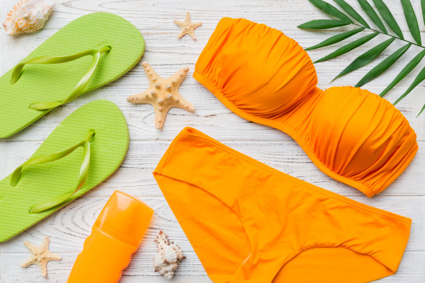 女子泳装和海滩配件平铺顶视彩色背景夏季旅行的概念。比基尼泳装，草帽和高跟鞋。复制空间俯视图图片下载