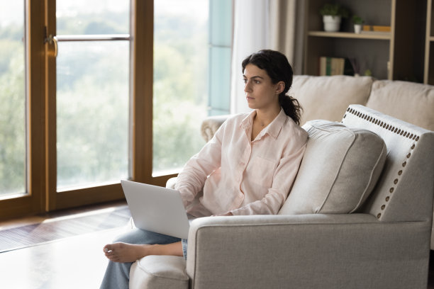 有思想的年轻拉丁女学生在笔记本电脑前工作分心图片下载