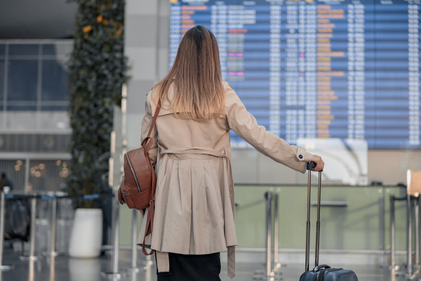 一位年轻女士在查看信息板，查看她的航班图片下载
