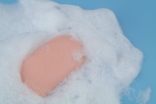 蓝色背景上有泡沫和肥皂。图片下载