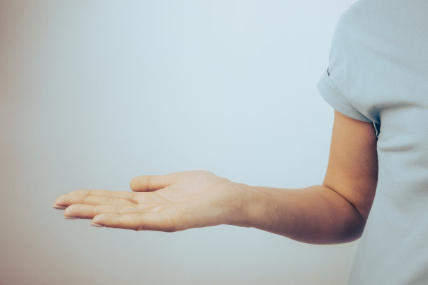 美丽的女人的手孤立在灰色背景与复制空间为您的产品图片下载