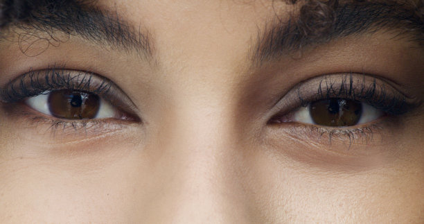 特写肖像的脸，眼睛和眉毛的一个女人向前看的相机。放大头像的女人盯着美丽的棕色虹膜。健康的眼部护理，清晰的视觉图片下载
