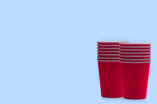 一堆红色纸杯的热外卖饮料隔离在蓝色的背景。图片下载