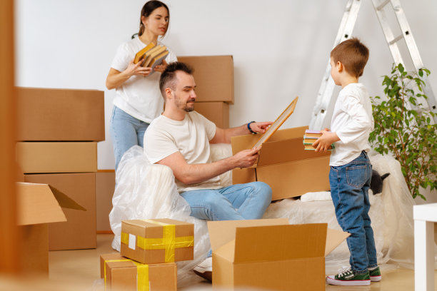 搬家的日子，一家人带着纸板箱在新家的肖像图片下载