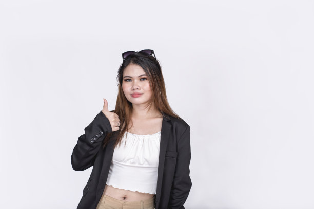 一个充满活力的时髦少女，还有个拇指手势。穿着黑色运动上衣和白色上衣，露出肚脐。图片下载