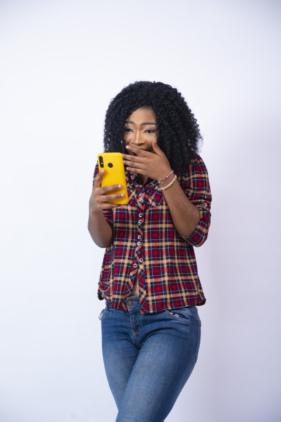 年轻的黑人女士看着她的手机感到惊讶和高兴图片下载