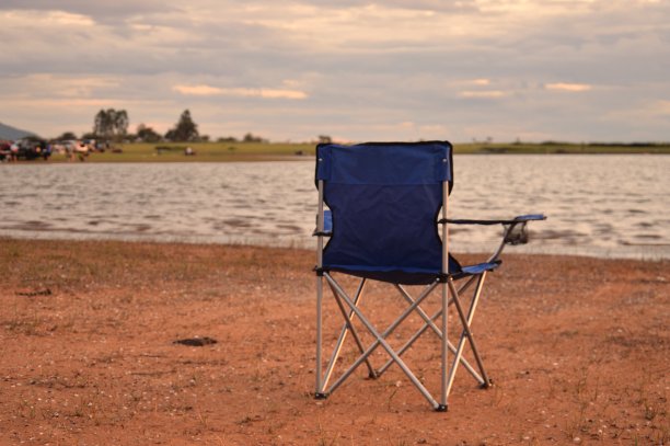 沙滩边的空椅子在暮色中伴着浓浓的黑云在雨季概念放松天气预报旅游度假拷贝空间图片下载