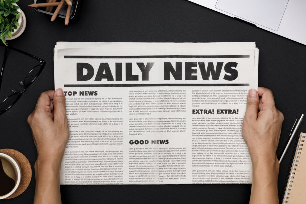 手拿商业报纸和办公用品笔记本，热咖啡杯，眼镜，书和配件的黑色书桌topview，日报模型概念图片下载