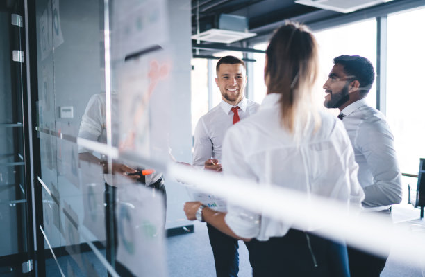 穿着正装的开朗的男同事和女同事在办公室享受友好的头脑风暴，快乐的经验丰富的商业伙伴讨论财务文件和微笑在室内图片下载